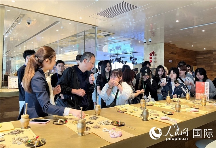 1. 日中友好協(xié)會青年代表團一行學習中醫(yī)香囊制作工序。（人民網記者陳思 攝）