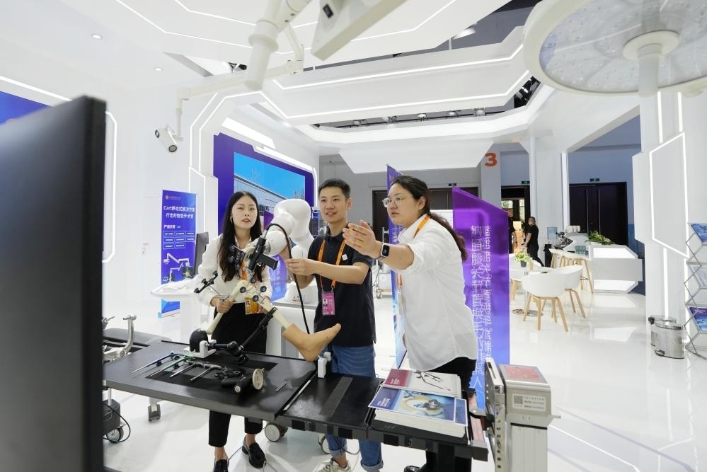 9月11日，一位媒體記者（中）在2024年服貿(mào)會(huì)國(guó)家會(huì)議中心會(huì)場(chǎng)體驗(yàn)北京納通科技集團(tuán)有限公司的膝關(guān)節(jié)置換手術(shù)機(jī)器人。新華社記者鞠煥宗 攝