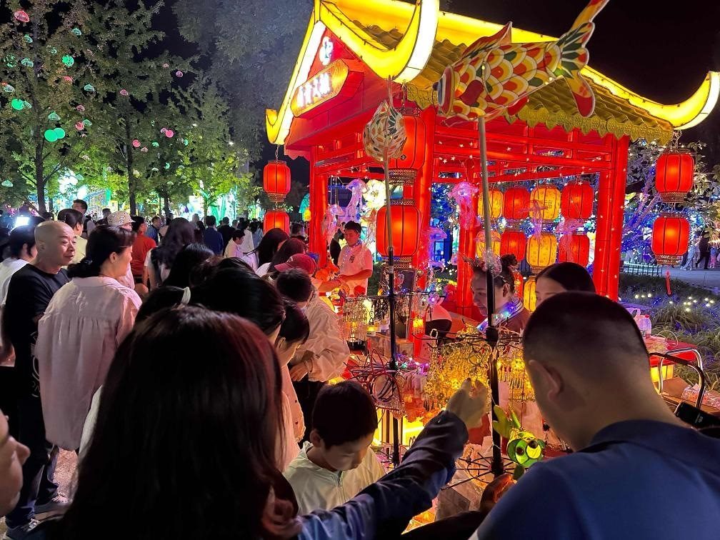 市民游客在2024年北京中秋國(guó)慶彩燈游園會(huì)上選購(gòu)特色文創(chuàng)商品。新華社記者楊淑君 攝