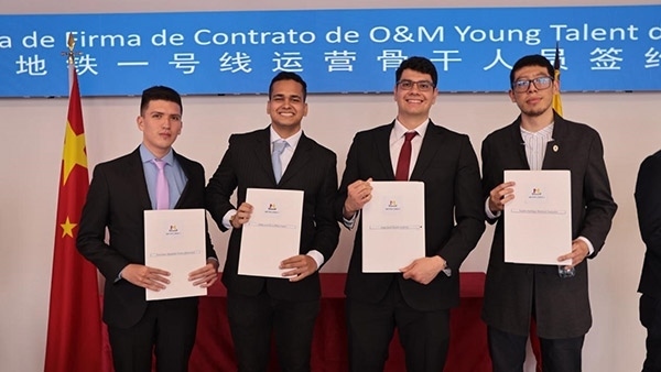 當?shù)貢r間9月13日，40名哥倫比亞青年與中企承建運營的波哥大地鐵一號線項目簽約，不久將前往中國進行為期15個月的專業(yè)地鐵知識培訓。圖為部分學員在簽約儀式上展示所簽的協(xié)議。 波哥大地鐵一號線項目供圖