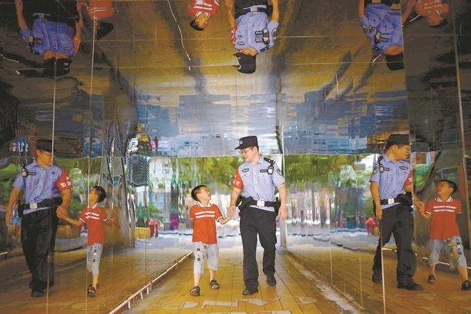 ?7月16日，重慶市公安局江北區(qū)分局一名民警在巡邏途中遇到一個(gè)獨(dú)自玩耍的小男孩，民警將其送回家。王洪平攝