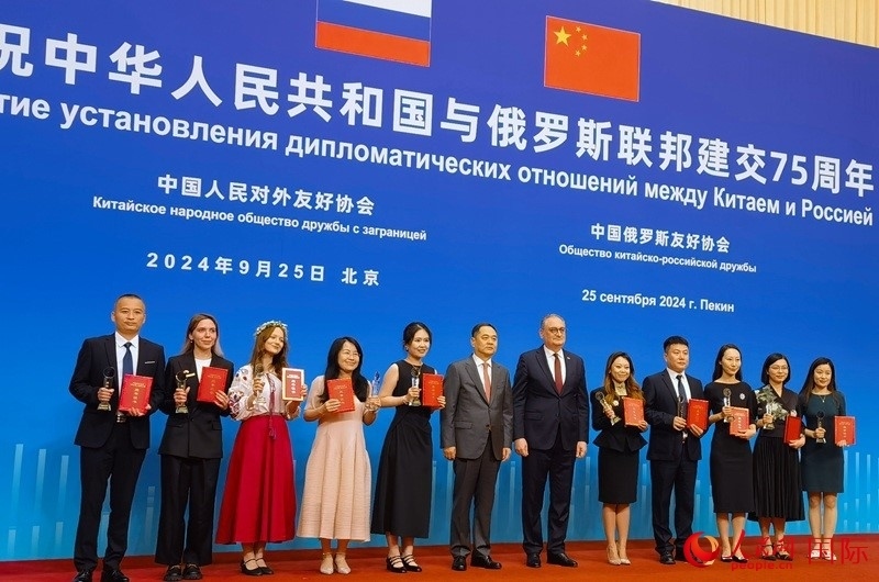 楊萬明會長和莫爾古洛夫大使為10位中俄青年友好微視頻創(chuàng)意大賽獲獎代表頒獎。人民網(wǎng)記者 李明琪攝