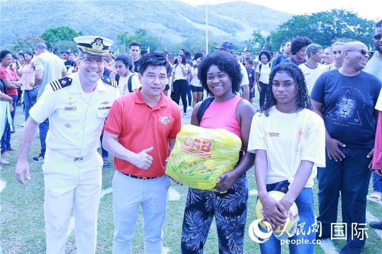 巴西中國浙江商會會長鄭俠茂向巴西貧困社區(qū)兒童及家庭捐贈基礎(chǔ)食品籃子和足球。人民網(wǎng)記者陳海琪 攝