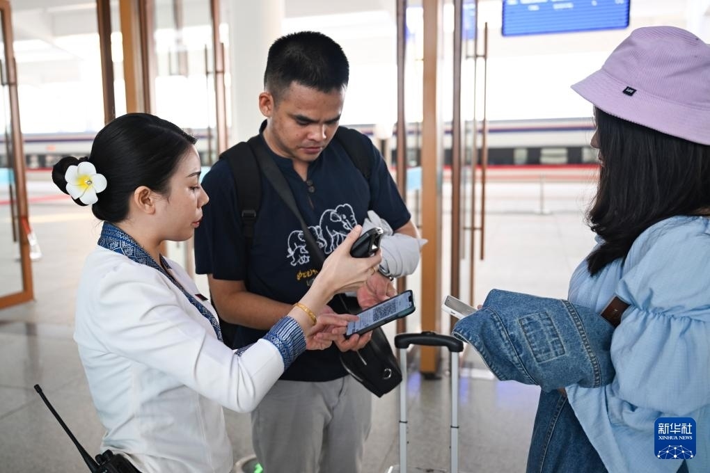 10月12日，在老撾萬象中老鐵路萬象站，工作人員檢驗乘客車票。新華社記者 程一恒 攝