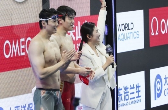  10月18日，汪順（左）和潘展樂在男子100米混合泳決賽后。新華社記者 方喆 攝