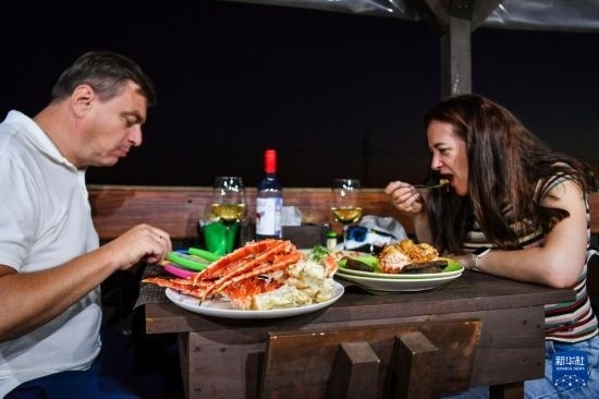 9月2日，食客們?cè)诙砹_斯符拉迪沃斯托克的一家餐館品嘗帝王蟹。新華社記者 曹陽(yáng) 攝