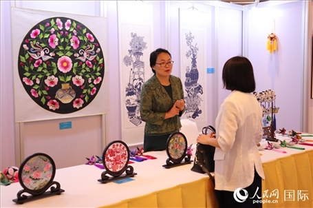 青海非遺文化傳承人向嘉賓介紹展品。人民網實習生姚欣可攝