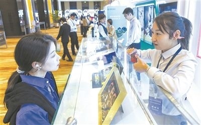 在北京麗澤商務區(qū)，工作人員（右一）介紹數字人民幣SIM卡硬錢包。新京報記者 陶冉攝