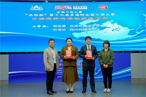 外交部亞洲司參贊張梅（右一）、中聯(lián)部副局長沈建國（左一）為獲得日語同傳組二等獎(jiǎng)的北京外國語大學(xué)岳忠昊、四川外國語大學(xué)樸雪蘭頒獎(jiǎng)（主辦方提供）