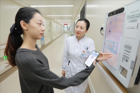 醫(yī)護人員引導患者在自助機前辦理自助入院手續(xù)。圖片來源：山東第一醫(yī)科大學第二附屬醫(yī)院