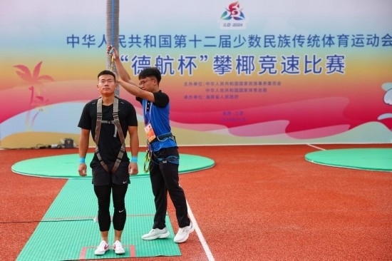 11月23日，工作人員為上海隊(duì)選手付樂樂（左）系安全繩。新華社記者 楊植森 攝