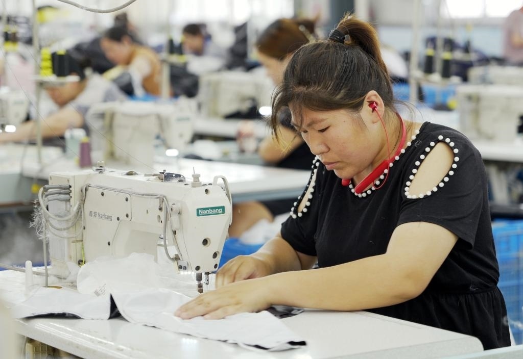 5月20日，村民在李寨村服裝加工廠內(nèi)忙碌。河南省周口市沈丘縣馮營鎮(zhèn)李寨村地處豫東平原。近年來，乘著脫貧攻堅(jiān)與鄉(xiāng)村振興政策的東風(fēng)，李寨村積極探索產(chǎn)業(yè)發(fā)展模式，通過“龍頭企業(yè)+村集體經(jīng)濟(jì)+農(nóng)戶”的方式，逐漸發(fā)展形成肉牛養(yǎng)殖、設(shè)施農(nóng)業(yè)、服裝加工、康養(yǎng)民宿等產(chǎn)業(yè)，以產(chǎn)業(yè)振興助力鄉(xiāng)村振興。新華社記者 李嘉南 攝