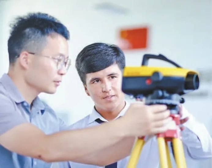 在塔吉克斯坦首都杜尚別的魯班工坊，來自天津城市建設(shè)管理職業(yè)技術(shù)學(xué)院的老師（左）為當(dāng)?shù)貙W(xué)生提供指導(dǎo)。新華社記者 鄭開君 攝