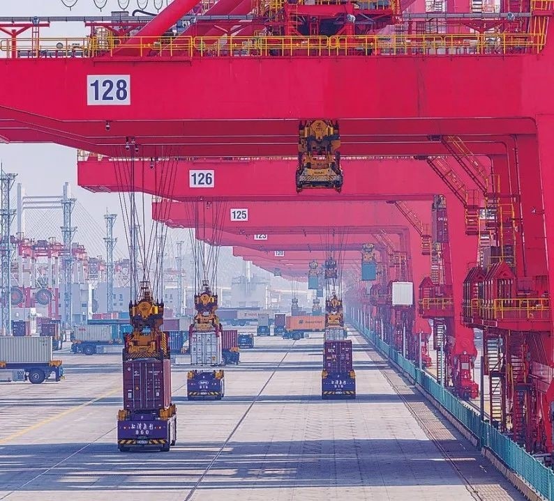 共建“一帶一路”國(guó)家在工作制度對(duì)接、技術(shù)標(biāo)準(zhǔn)協(xié)調(diào)、檢驗(yàn)結(jié)果互認(rèn)等方面強(qiáng)化合作、統(tǒng)一標(biāo)準(zhǔn)，貿(mào)易自由化便利化水平不斷提升。上海洋山港海關(guān)對(duì)接共建國(guó)家進(jìn)出口貨物相關(guān)標(biāo)準(zhǔn)，推動(dòng)通關(guān)一體化方式申報(bào)，提升通關(guān)效率。圖為無(wú)人駕駛的全自動(dòng)導(dǎo)引車在洋山港穿梭往來，搬運(yùn)集裝箱。王初 攝