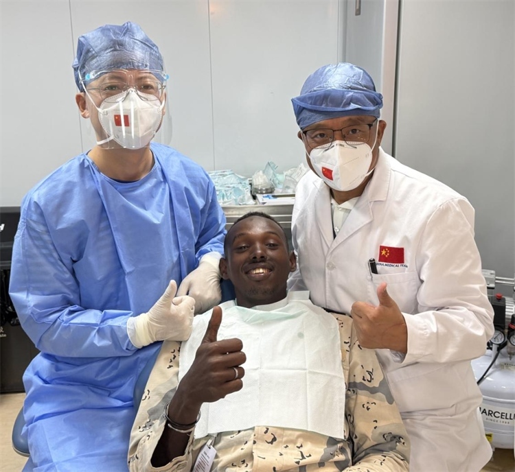 援吉醫(yī)療隊口腔科王瑋主任與“和平方舟”號醫(yī)院船醫(yī)務(wù)人員共同為一名當(dāng)?shù)匮浪柩谆颊咴\療。中國（山西）第23批援吉布提醫(yī)療隊供圖