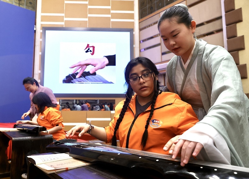 2024年3月20日，美國(guó)華盛頓州中學(xué)生代表團(tuán)北京大學(xué)交流活動(dòng)在北京大學(xué)英杰交流中心舉行。圖為來(lái)自華盛頓州的中學(xué)生體驗(yàn)古琴。