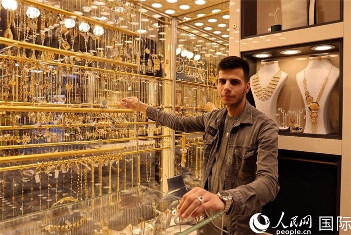 一名銷(xiāo)售員展示黃金飾品。人民網(wǎng) 伊納斯·易卜拉欣攝