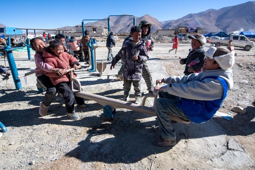 1月11日，在定日縣措果鄉(xiāng)塘仁村安置點(diǎn)，西藏星光社會工作服務(wù)中心志愿者和孩子們一起玩耍，進(jìn)行災(zāi)后心理疏導(dǎo)。人民網(wǎng)記者 翁奇羽攝