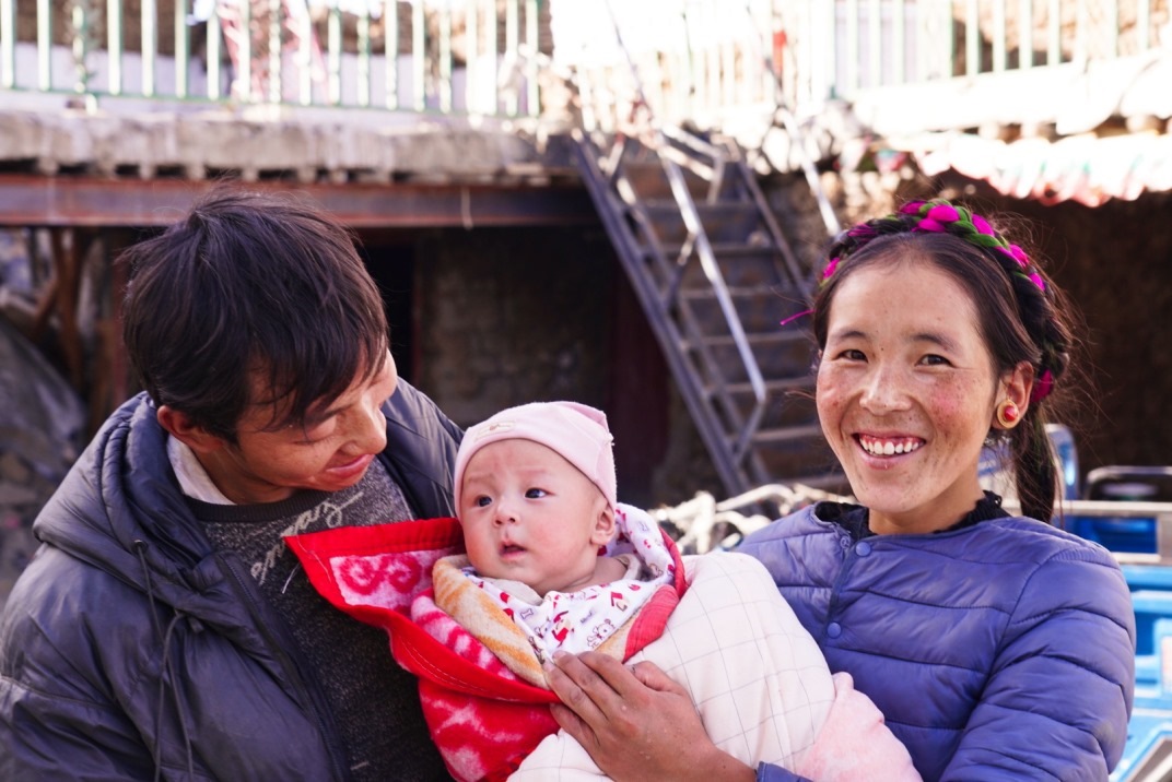 1月11日，在西藏日喀則市人民醫(yī)院，受災(zāi)群眾抱著自己在地震中受傷的孩子康復(fù)出院。人民日報(bào)記者徐馭堯攝
