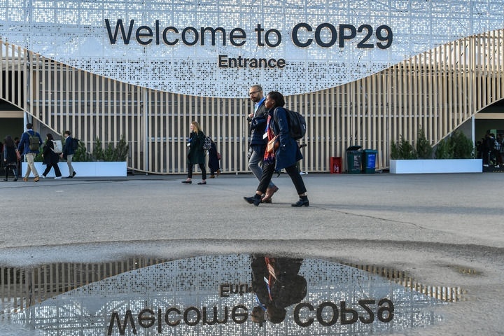 2024年11月15日，在阿塞拜疆首都巴庫，人們經(jīng)過聯(lián)合國氣候變化巴庫大會的會場。新華社記者 曹陽 攝