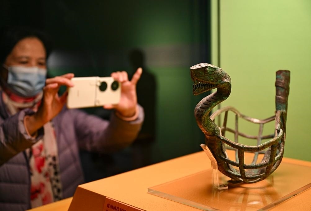 1月14日，觀眾在上海博物館蛇年迎春展拍攝展品蛇綱網狀銅器。新華社發(fā)（陳浩明攝）