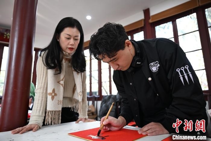1月20日，外籍留學(xué)生在西泠印社社員李硯指導(dǎo)下寫(xiě)福。當(dāng)日，來(lái)自巴西、馬來(lái)西亞、加納、哈薩克斯坦的外籍留學(xué)生在浙江杭州西泠印社體驗(yàn)福貼、春聯(lián)和篆刻，感受古老的中國(guó)傳統(tǒng)文化。中新社記者 王剛 攝