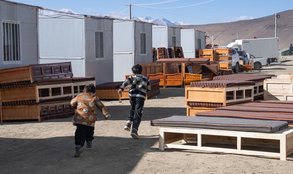 2025年1月13日，在定日縣嘎旦村，兩個孩子在剛運來的兩排藏床間奔跑。新華社記者丁增尼達(dá) 攝