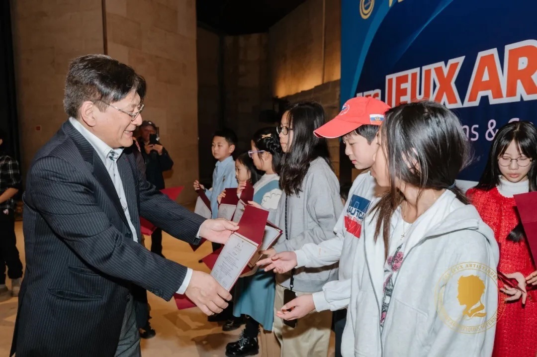 圖2：亞丁為獲獎兒童頒發(fā)證書。法中交流促進(jìn)會供圖