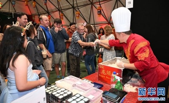 圖為游客在燈節(jié)現(xiàn)場(chǎng)購(gòu)買(mǎi)小吃。（圖片由奧克蘭中國(guó)文化中心提供）