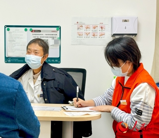 秦苑（中）接診患者。人民網(wǎng)記者 金慧慧攝