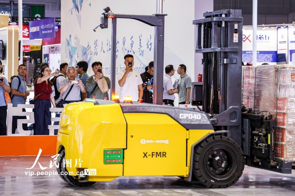 第24屆中國(guó)工博會(huì)現(xiàn)場(chǎng)，觀眾觀看叉取機(jī)器人作業(yè)演示。王初攝（人民圖片網(wǎng)）