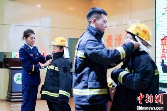 圖為學(xué)生們現(xiàn)場穿戴消防頭盔和戰(zhàn)斗服。中新社記者 趙宇航 攝