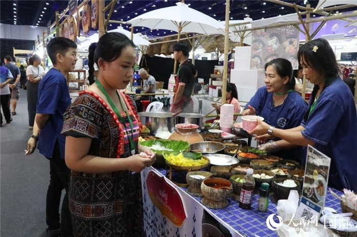 游客在攤位前購買特色美食。朱瀟逸攝