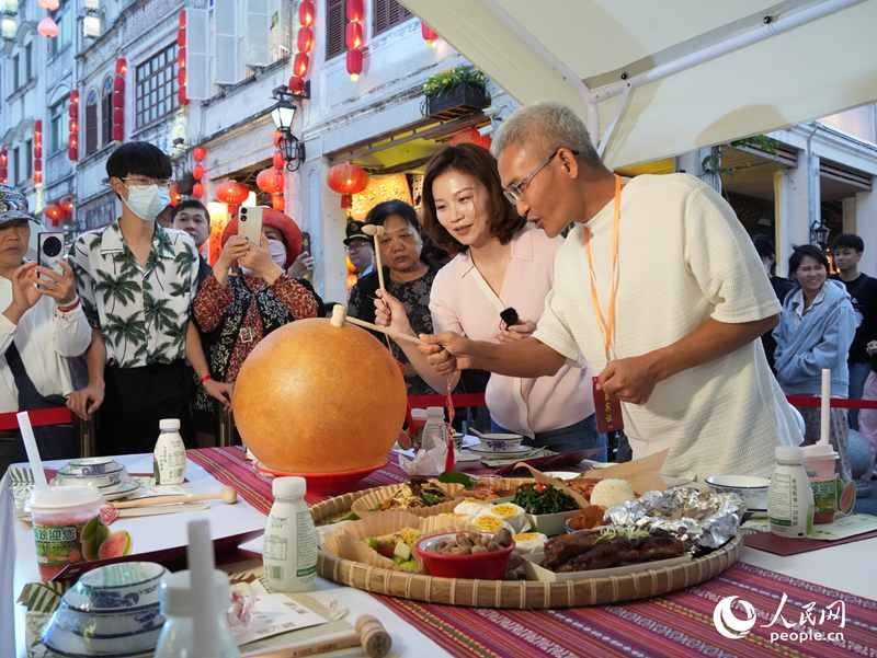 嘉賓品嘗海南傳統(tǒng)美食“煎堆”。人民網(wǎng)記者 張力洋攝