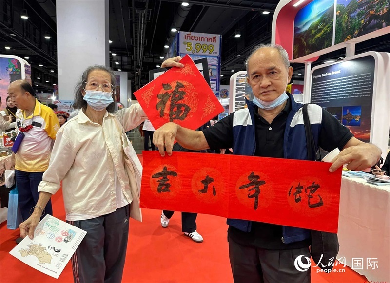 2025蛇年春節(jié)，泰國市民展示他們領(lǐng)到的華人手寫春聯(lián)。人民網(wǎng)記者 簡承淵攝
