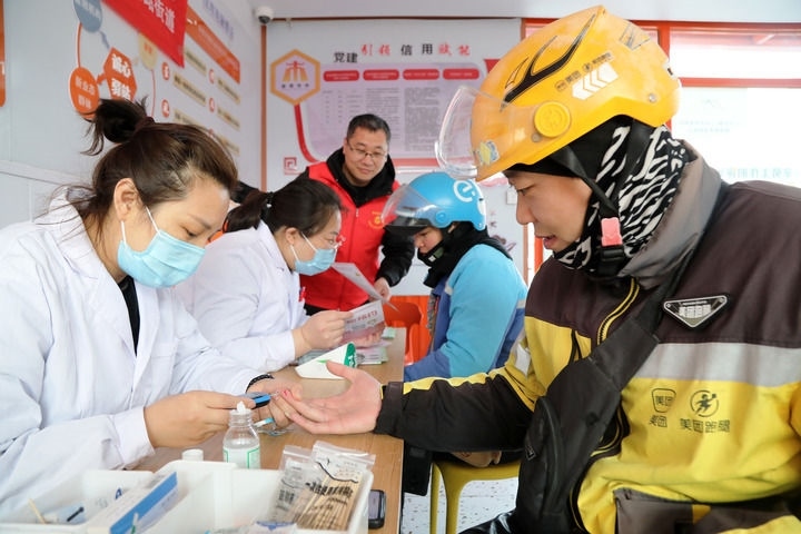 2025年3月5日，志愿者在山東省棗莊市市中區(qū)一工會(huì)驛站為外賣員免費(fèi)測(cè)量血糖。新華社發(fā)（王海楠攝）