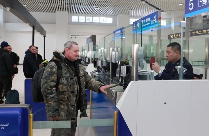 2024年12月10日，在黑河公路口岸旅檢大廳，黑河出入境邊防檢查站民警為首班次客車入境旅客辦理邊檢通關(guān)手續(xù)。當(dāng)日，中國黑河公路口岸—俄羅斯卡尼庫爾干公路口岸旅客運(yùn)輸正式開通。新華社發(fā)（劉松攝）