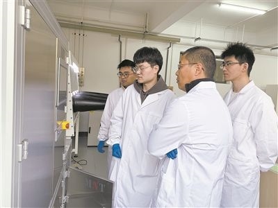 圖為安工大材料科學與工程學院碩士研究生余威（右一）在實驗室開展研究。安工大供圖