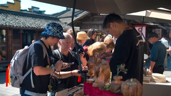 “五一”期間，游客正在烏鎮(zhèn)“水鄉(xiāng)碼頭”挑選購買文創(chuàng)產(chǎn)品。受訪者供圖