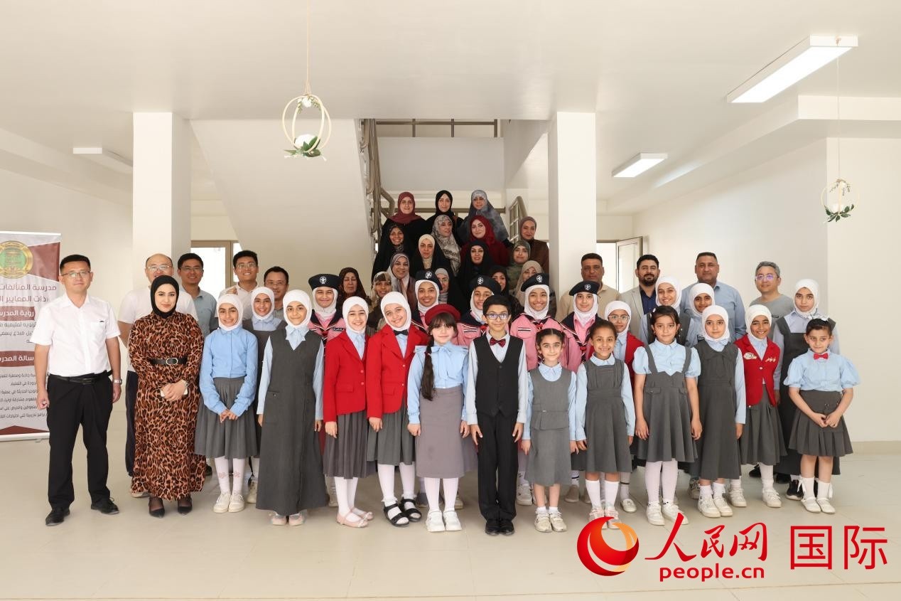 中國電建員工與阿爾穆塔?阿里卡特國際學校的師生及政府官員等合影。人民網(wǎng)記者 薛丹攝