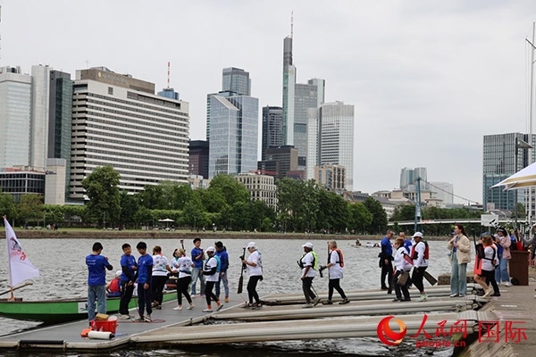 來(lái)自美國(guó)的快樂(lè)龍舟隊(duì)選手們正在登船準(zhǔn)備參賽。人民網(wǎng)記者 劉仲華攝