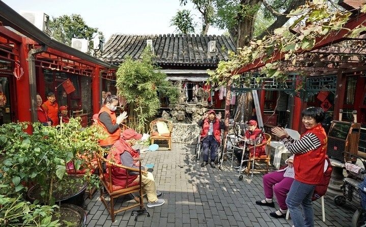 2024年10月12日，鐘樓灣胡同的老年人在社區(qū)內(nèi)的四合院養(yǎng)老驛站休閑。2017年起，北京市先后開展了兩輪背街小巷環(huán)境整治提升行動(dòng)，完整保留了中軸線生活建筑群的歷史信息，并根據(jù)居民的生活和居住方式進(jìn)行適配化的更新和改造，極大地改善了生活環(huán)境。2023年鐘樓灣胡同被評(píng)為“北京最美街巷”。