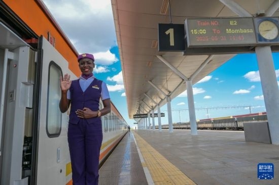 5月31日，在蒙內(nèi)鐵路內(nèi)羅畢站，一名乘務員在即將開往蒙巴薩的E2次列車旁等候乘客。新華社記者 楊光 攝