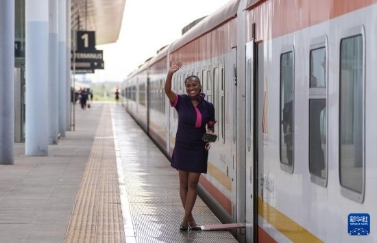 5月31日，在蒙內(nèi)鐵路內(nèi)羅畢站，一名乘務員在即將開往蒙巴薩的E2次列車旁等候乘客。新華社記者 李亞輝 攝