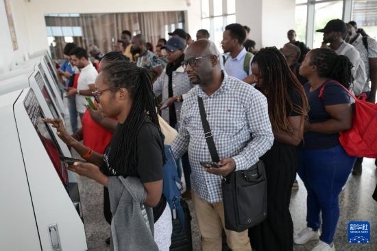 5月31日，在蒙內(nèi)鐵路內(nèi)羅畢站，乘客在自助取票機前排隊取票。新華社記者 楊光 攝