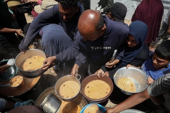 5月28日，人們?cè)诩由吵俏鞑康纳程犭y民營(yíng)領(lǐng)取救助食物。新華社發(fā)（里澤克·阿卜杜勒賈瓦德攝）