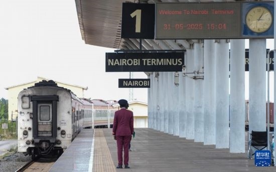 5月31日，在蒙內(nèi)鐵路內(nèi)羅畢站，工作人員目送開往蒙巴薩的E2次列車駛離站臺。新華社記者 李亞輝 攝