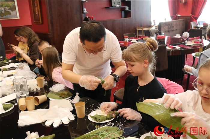 烏克蘭兒童學(xué)習(xí)體驗包粽子。人民網(wǎng)記者蔡子暢攝